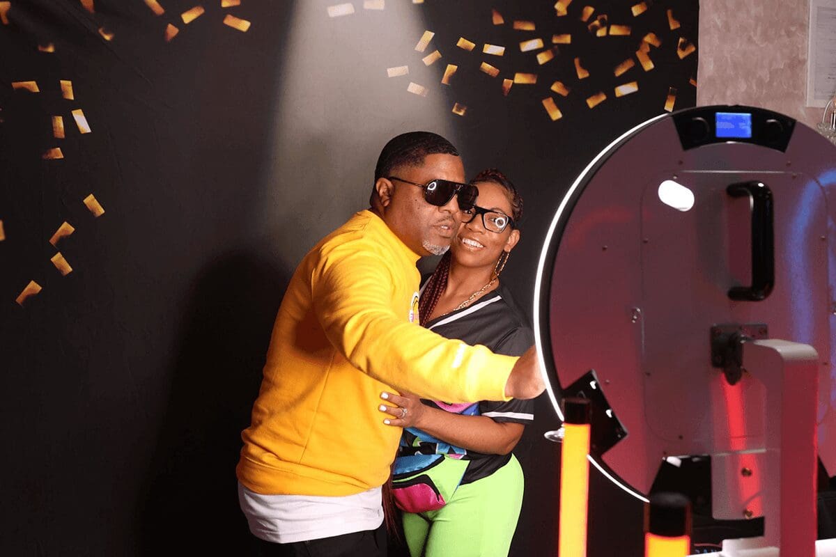 A man and woman posing for a picture in front of a mirror.