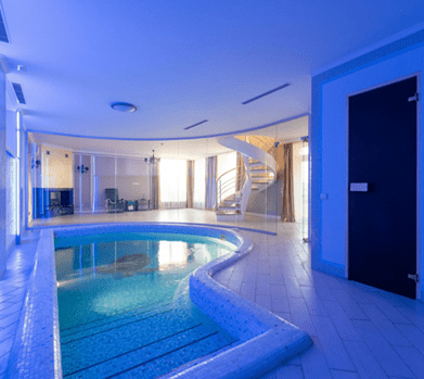 A large indoor pool with stairs leading to the bottom.