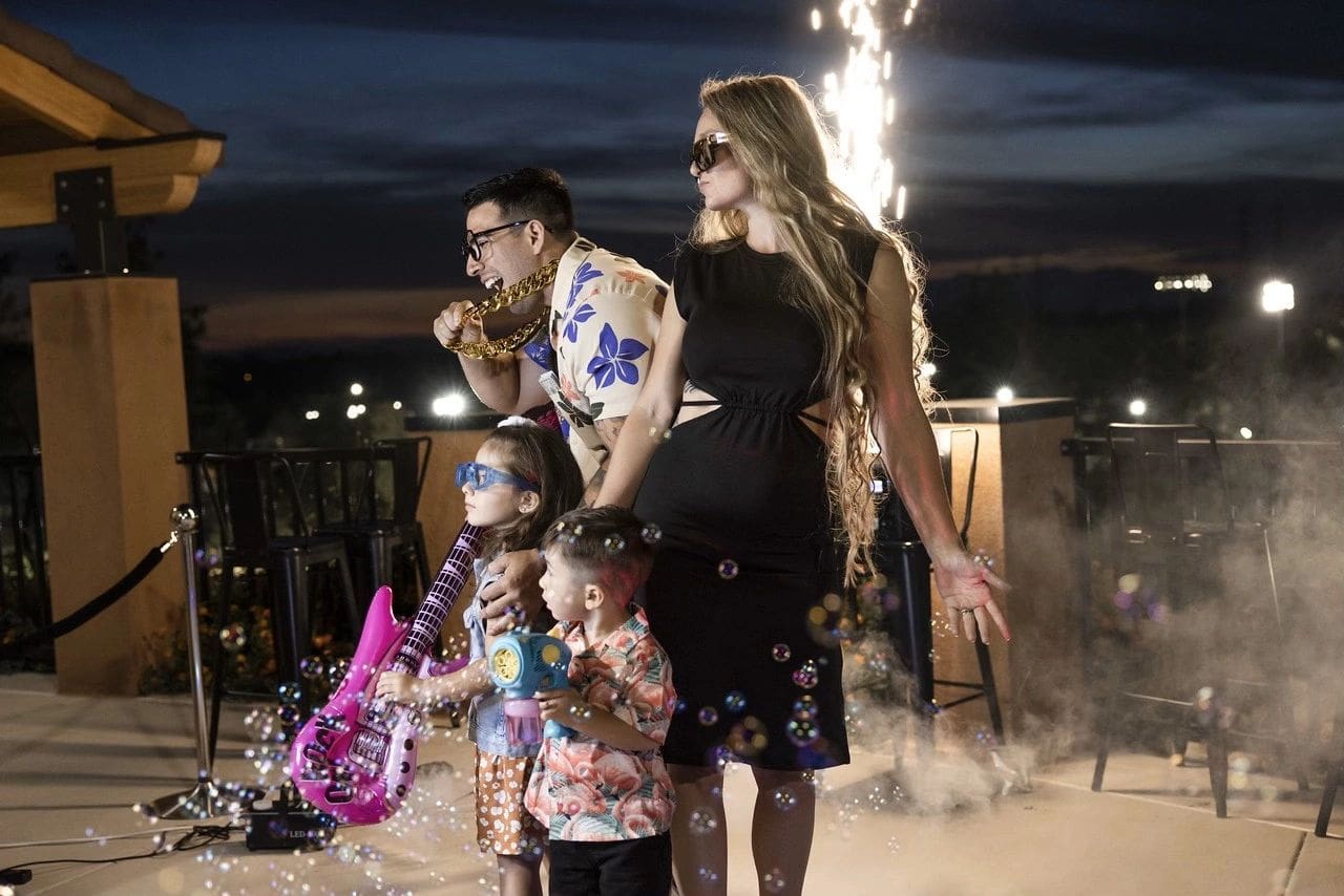 A family is standing on the beach at night.